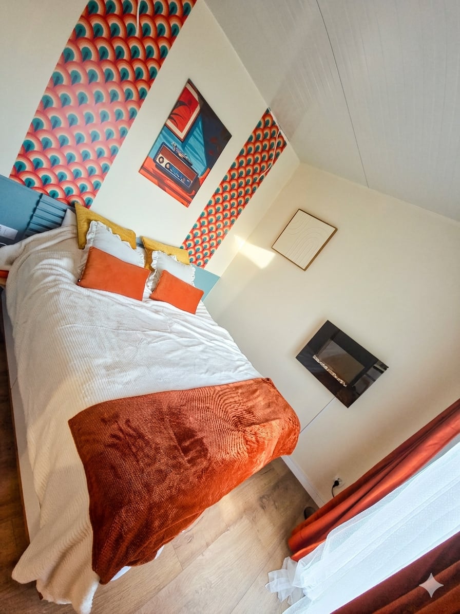 Przytulna sypialnia z łóżkiem 160x200, kolorowymi akcentami i kominkiem elektrycznym